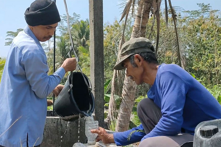 Warga Desa Sidomulyo, Kecamatan Pengasih, Kabupaten Kulon Progo, Daerah Istimewa Yogyakarta bergiliran menimba dari satu-satunya sumur yang masih mengeluarkan air, di sekitar pemukiman mereka.