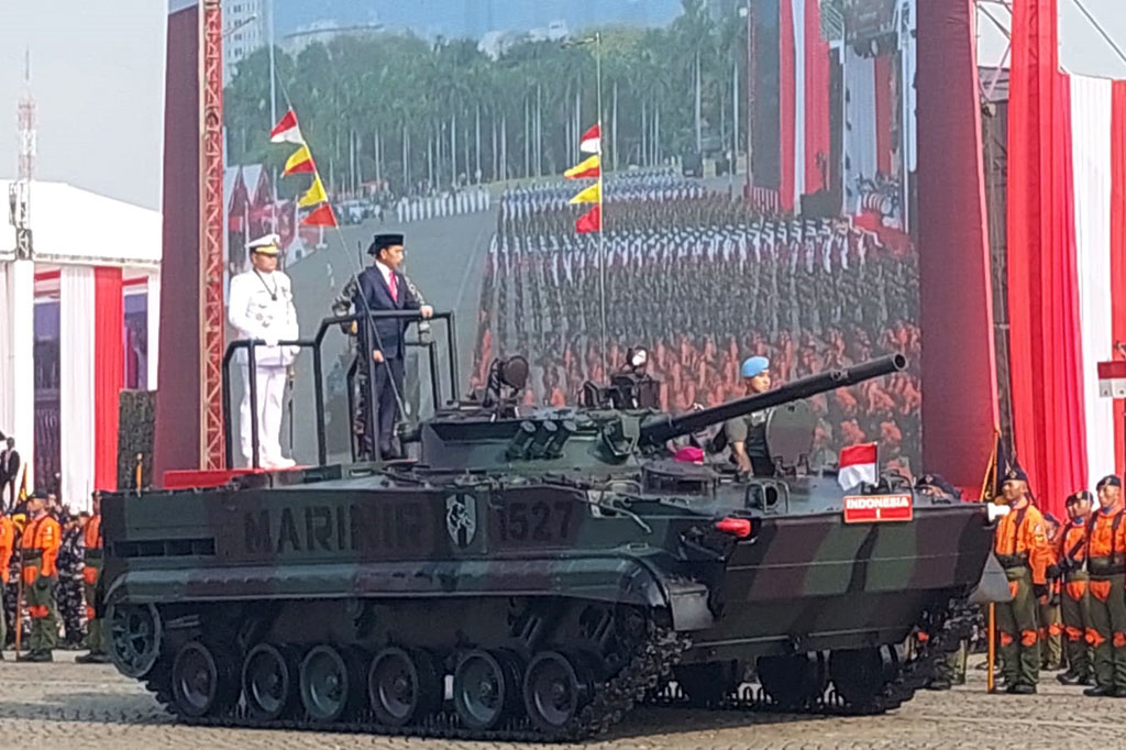 Pantaun Medcom.id Presiden menggunakan jas hitam, peci hitam, dan dasi merah saat menaiki tank ambifi BMP-3F. Sedangkan Yudo mengenakan pakaian dinas TNI Angkatan Laut. 