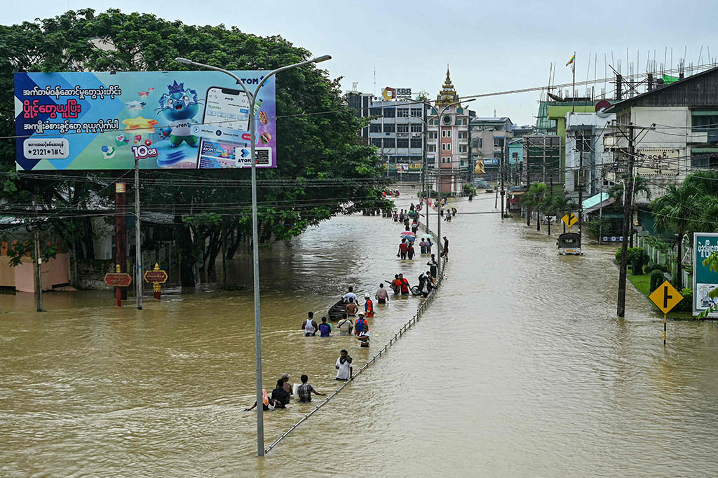 Di bagian timur kota Bago, penduduk mengarungi jalan melalui air setinggi pinggang atau mengapung dengan perahu atau ban karet, ketika riak-riak terjadi di toko-toko dan rumah-rumah yang tutup.