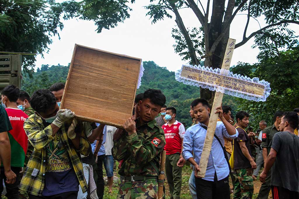 Warga membawa peti mati saat pemakaman massal berlangsung untuk menguburkan para korban serangan militer di sebuah kamp pengungsi dekat Kota Laiza, Myanmar utara pada Selasa, 10 Oktober 2023.
