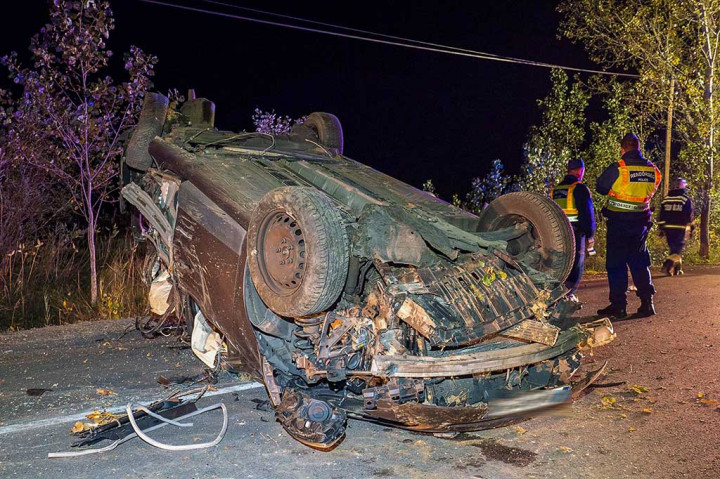 Petugas polisi Hongaria berdiri di samping puing-puing mobil yang terbalik setelah kecelakaan di dekat Kiskunmajsa, Hongaria selatan, sekitar 40 km dari perbatasan Serbia, Kamis, 12 Oktober 2023.