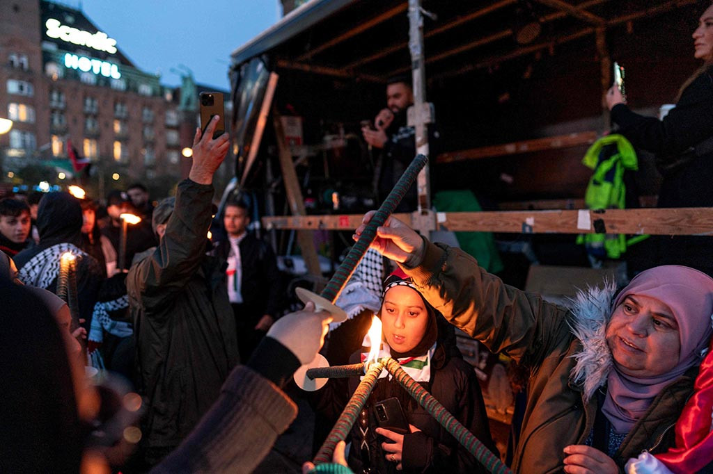 Para pengunjuk rasa berkumpul di Norrebro di Kopenhagen barat, banyak yang membawa bendera dan spanduk dengan slogan-slogan seperti 'Genosida sedang terjadi' dan 'Hentikan pembunuhan anak-anak Palestina yang tidak bersalah'.