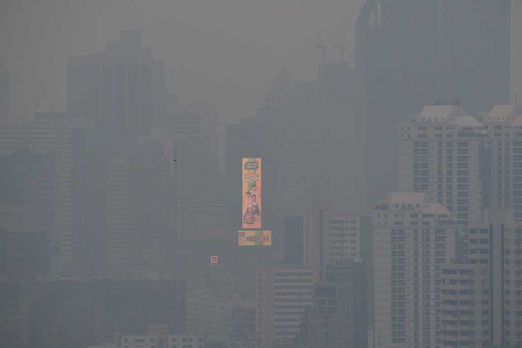 Sebuah iklan besar yang menyala di sisi sebuah bangunan terlihat di tengah tingginya tingkat polusi udara di Bangkok, Thailand, Rabu, 18 Oktober 2023.