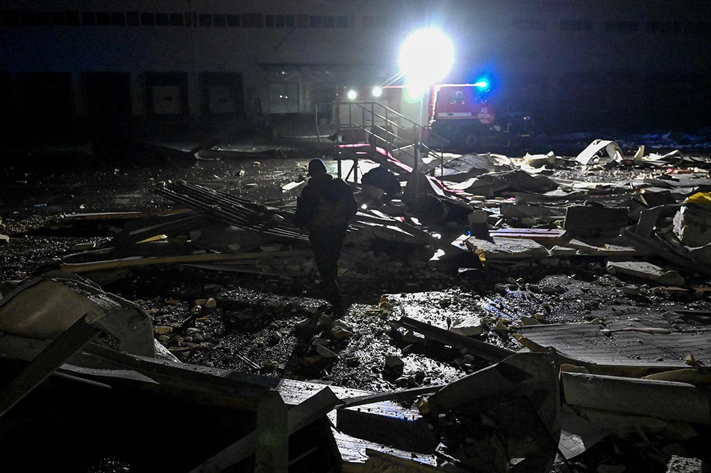 Presiden Volodymyr Zelensky membagikan video di media sosial yang menunjukkan sebuah gudang rusak berat yang dikelilingi puing-puing dan sebuah kontainer berlogo operator pos Ukraina Nova Poshta.