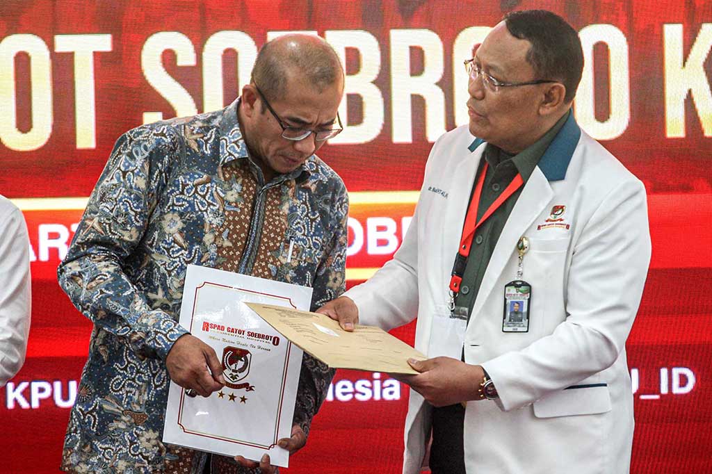 Ketua KPU Hasyim Asy'ari (kiri) menerima berkas hasil tes kesehatan tiga pasangan calon capres-cawapres dari Kepala RSPAD Gatot Soebroto Letjen Albertus Budi Sulistya dengan didampingi jajaran Anggota KPU dan tim doker di Kantor KPU, Jakarta, Jumat, 27 Oktober 2023. Hasil tes kesehatan tersebut menjadi syarat wajib untuk maju dalam Pilpres 2024.