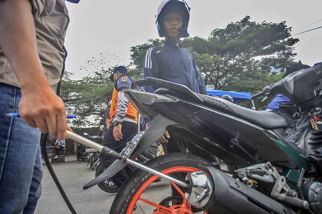 Petugas Suku Dinas Lingkungan Hidup Jakarta Selatan menguji emisi kendaraan bermotor saat digelarnya tilang uji emisi di Jalan Perintis Kemerdekaan, Jakarta, Rabu, 1 November 2023.