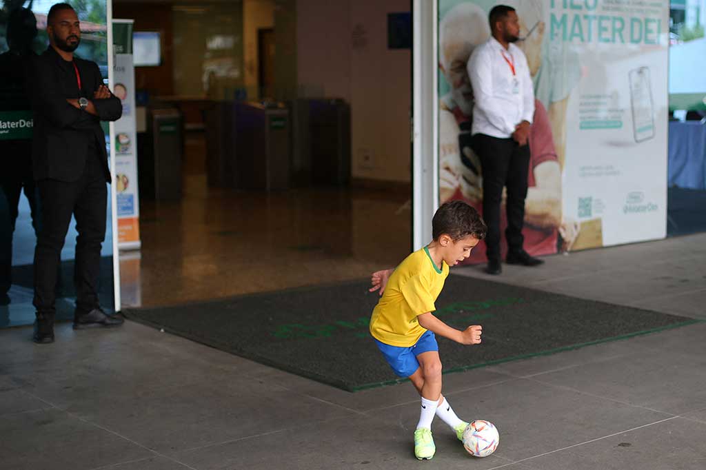 Seorang anak yang mengenakan kaos tim nasional Brasil bermain bola di luar Rumah Sakit Mater Dei, tempat penyerang Brasil Neymar menjalani operasi, di Belo Horizonte, Brasil, Kamis, 2 November 2023 waktu setempat.
