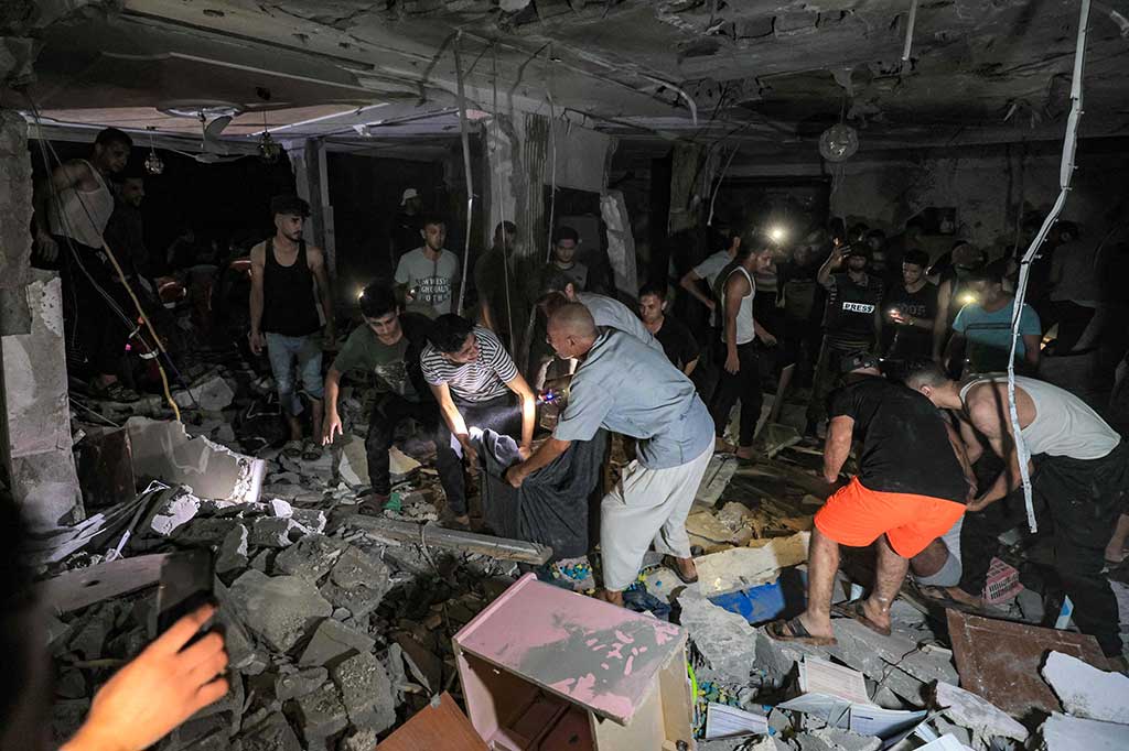 Tim penyelamat dan orang-orang melakukan evakuasi terhadap para korban di rumah jurnalis TV Palestina Mohammed Abu Hatab, yang terbunuh bersama anggota keluarganya selama pemboman Israel di Khan Yunis, Jalur Gaza, Kamis, 2 November 2023 waktu semtepat.