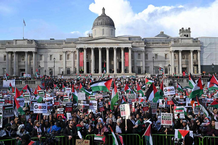 Sambil mengibarkan bendera Palestina, massa meneriakkan slogan pro Palestina termasuk 'Dari Sungai hingga laut, Palestina akan bebas' (From the river to the sea, Palestine will be free).