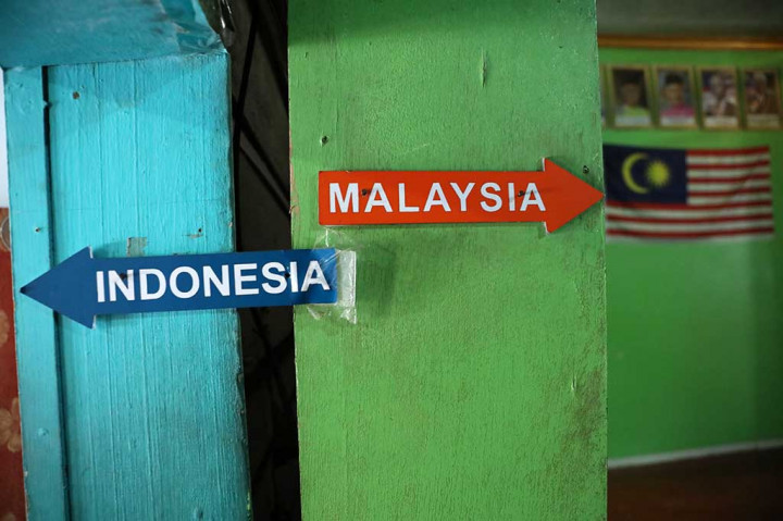 Rumah tersebut tergolong unik karena terbelah menjadi dua bagian yang berdiri di atas dua negara, yakni Indonesia dan Malaysia. Penunjuk arah Indonesia dan Malaysia yang menunjukkan arah ruangan di rumah dua negara.