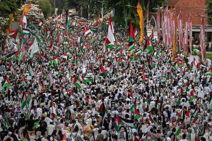 Massa aksi damai berdatangan dengan membawa bendera, syal, hingga poster, dan spanduk bergambar bendera Palestina serta tulisan bernada dukungan.