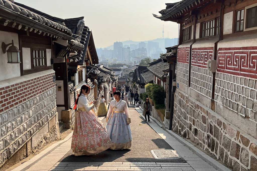 Bukchon Hanok Village jadi kawasan di Seoul, Korea Selatan yang ramai didatangi pengunjung dari berbagai negara. Pemandangan pertama yang bisa dilihat adalah banyaknya orang-orang berpakaian khas Korea Selatan, Hanbok. Pakaian tradisional Negeri Ginseng itu bisa disewa di area pedesaan yang bersih dan tenang tersebut.