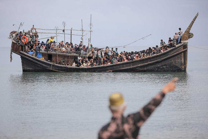 Perahu yang membawa anggota minoritas Myanmar yang teraniaya, banyak yang bertelanjang kaki dan beberapa memohon bantuan, berada di lepas pantai Provinsi Aceh.