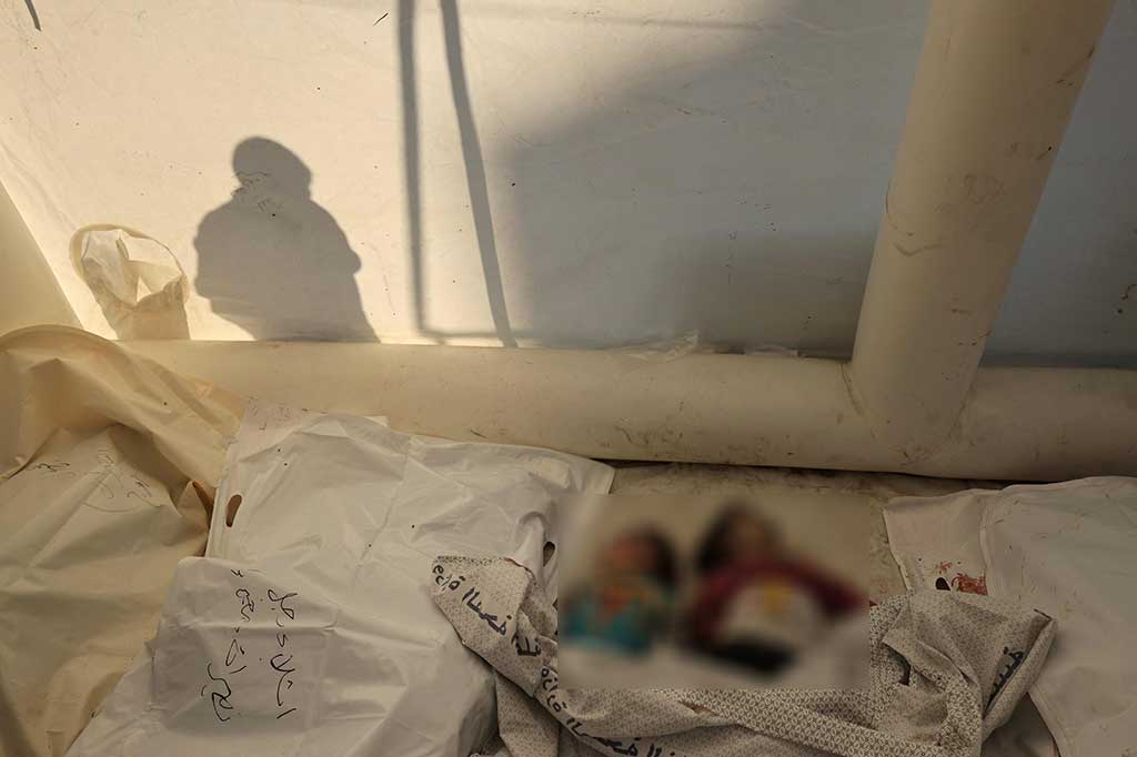 Bayangan seseorang terlihat di dekat jenazah anak-anak Palestina yang menjadi korban pemboman Israel, di kamar mayat Rumah Sakit Al-Aqsa di Deir al-Balah, Jalur Gaza, Jumat, 17 November 2023.