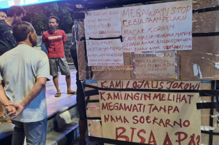 Sejumlah narasi dengan warna merah darah di lembaran kardus yang lumayan besar itu berbunyi: 'PDIP/Megawati Hobi Pelaku Macak Korban', lalu 'Kau Hina Presiden Terbaik Kami', dan 'Kami Loyalis Jokowi, Kami ingin Melihat Megawati Tanpa Nama Soekarno Bisa Apa' serta 'Mahfud MD Jadi Setan Demi Kekuasaan'.