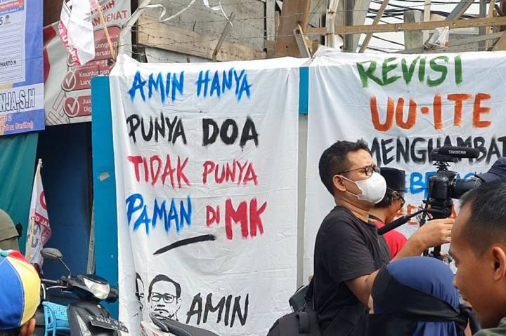 Warga ada yang menyambut dengan memainkan kentongan. Tak ketinggalan sejumlah spanduk dari kain dan dituliskan berbagai macam ucapan. 'Amin hanya punya doa tidak punya paman di MK', tulis salah satu spanduk.