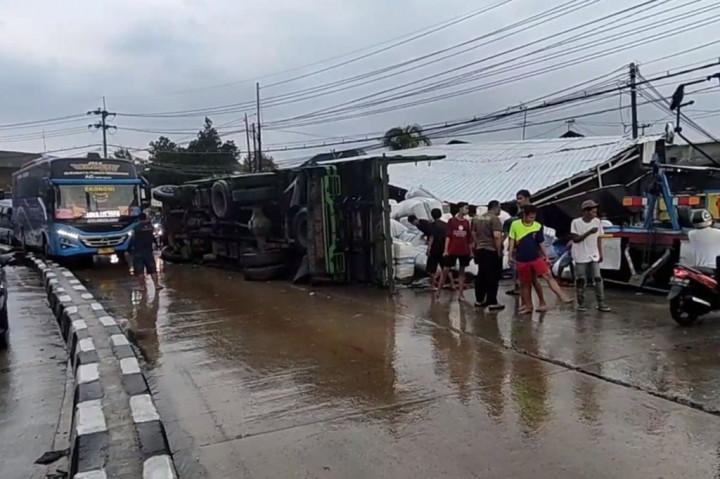 Sebuah truk ekspedisi penuh muatan mengalami selip ban dan menabrak warung kopi di jalur poros pantura Kabupaten Lamongan, Jawa Timur, Minggu, 3 Desember 2023. Akibatnya, truk terguling menutup seluruh badan jalan. Beruntung tidak ada korban dalam kecelakaan ini.