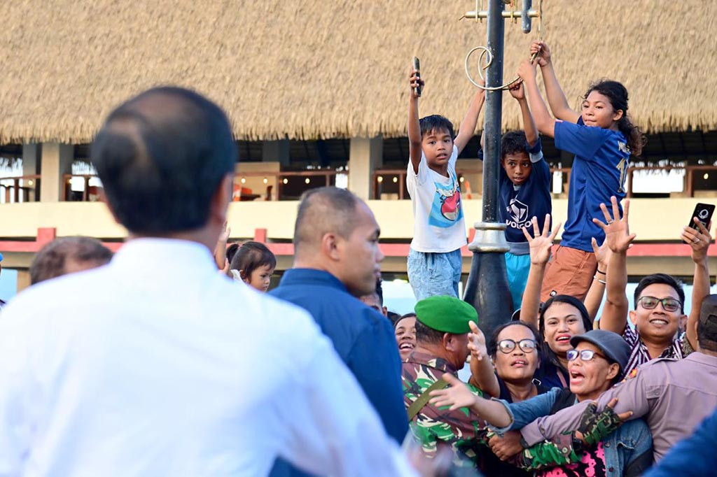 Sambil berjalan, Presiden Jokowi pun menyapa para masyarakat dan juga beberapa kali menerima ajakan swafoto dari mereka.