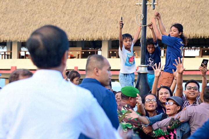 Sambil berjalan, Presiden Jokowi pun menyapa para masyarakat dan juga beberapa kali menerima ajakan swafoto dari mereka.