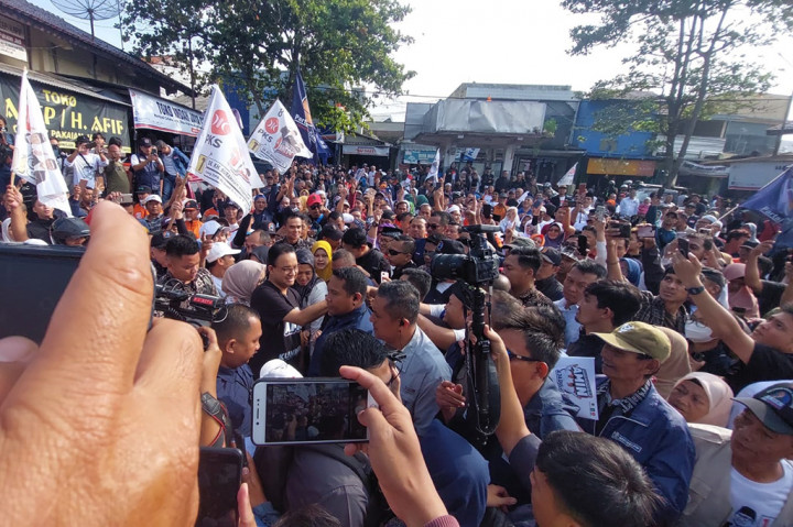 Masyarakat pun terus mendampingi Anies dan Feri masuk ke dalam pasar. Selain itu, sejumlah pendukung yang hadir membawa bendera berlogo partai pengusung, baik itu PKS, Partai NasDem, dan PKB. 