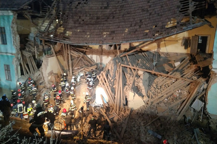 Petugas pemadam kebakaran bekerja di antara puing-puing untuk menyelamatkan seorang korban setelah gedung asrama sekolah menengah 'Tamasi Aron' di Kota Odorheiul Secuiesc, Rumania, tiba-tiba runtuh, Senin, 18 Desember 2023 waktu setempat.