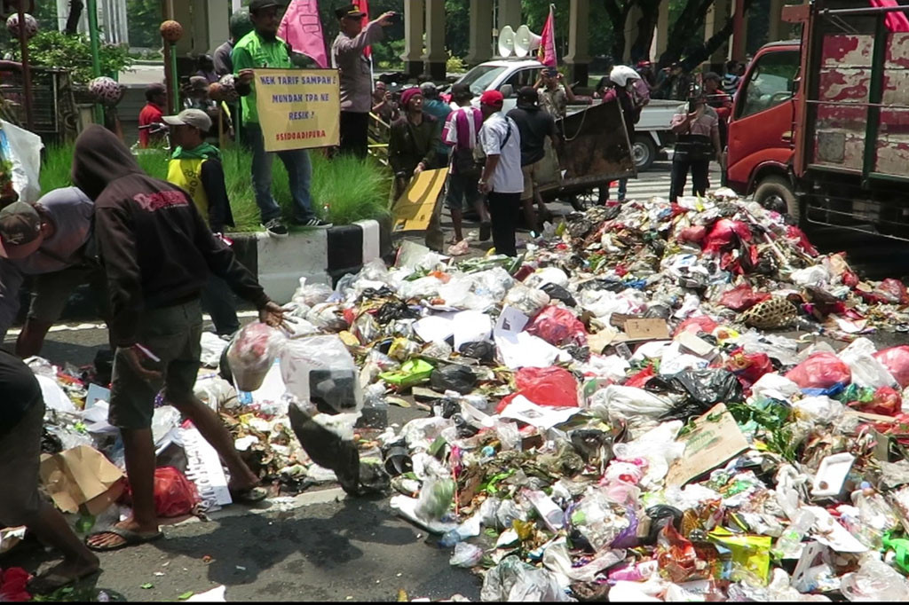 Puluhan pekerja sampah berunjuk rasa memprotes kenaikan tarif angkut di depan Pendopo Kabupaten Sidoarjo, Rabu, 20 Desember 2023. Mereka kemudian membuang sampah yang dibawa dengan gerobak di jalan depan pendopo, sehingga mengotori dan menimbulkan bau menyengat di area pendopo dan rumah dinas bupati.