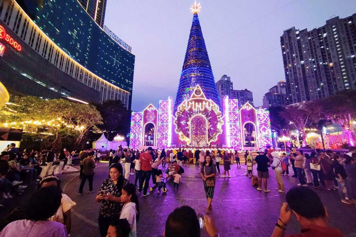 Warga menikmati pertunjukan lampu pohon natal tertinggi di Indonesia setinggi 38 meter, yang kembali dihadirkan oleh Central Park Mall, Jakarta, Sabtu, 23 Desember 2023. 