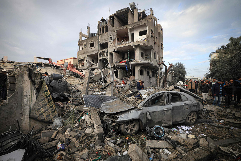 Warga Palestina memeriksa kerusakan di kamp pengungsi Al-Maghazi setelah serangan Israel semalam, pada 25 Desember 2023.