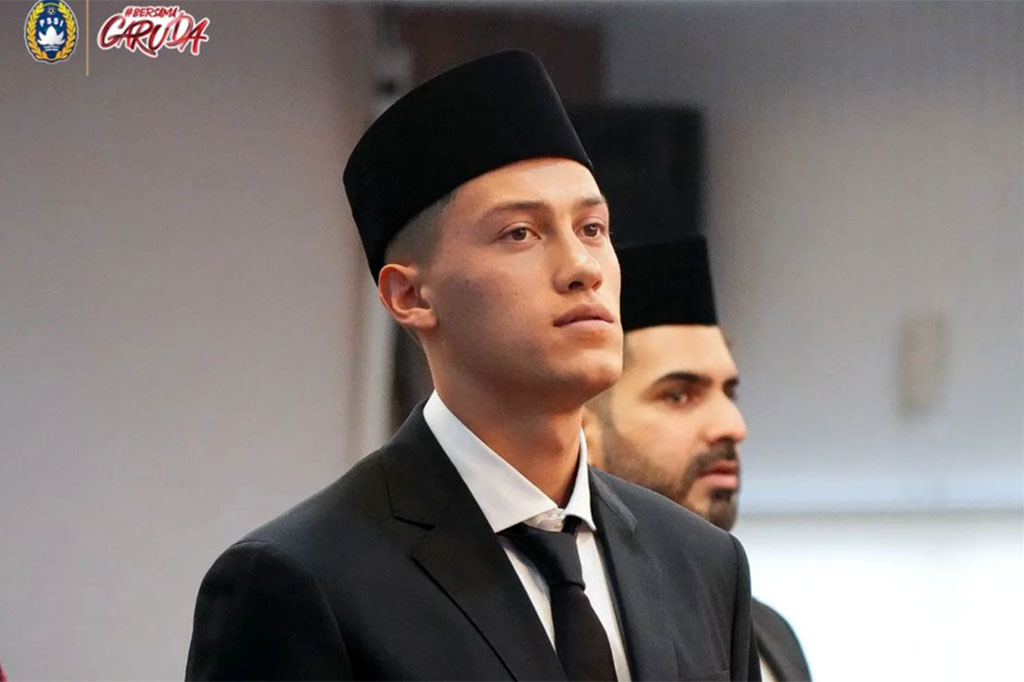 Jay Idzes hadir mengenakan jas lengkap warna hitam, dasi merah, dan kopiah.