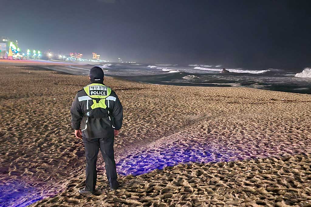 Seorang anggota Penjaga Pantai Korea Selatan berpatroli di pantai di Gangneung pada 1 Januari 2024, saat Korea Selatan mengeluarkan peringatan tsunami setelah gempa dahsyat mengguncang Jepang.