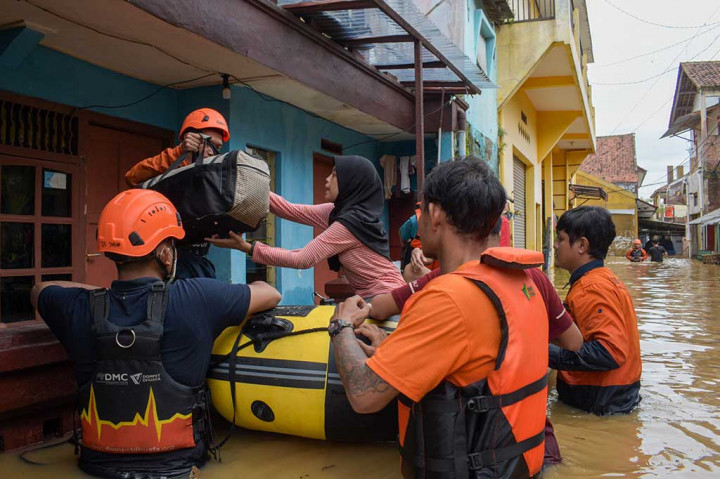 Warga korban banjir dibantu tim SAR mengungsi ke tempat yang lebih aman dari luapan banjir.