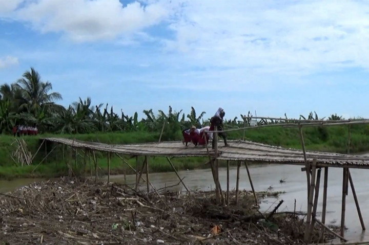 Secara bergantian, para siswa ini menyeberang agar bisa bersekolah ke wilayah sebelahnya. Warga lain yang juga beraktifitas untuk bekerja maupun bertani juga terpaksa menggunakan jembatan miring tersebut.