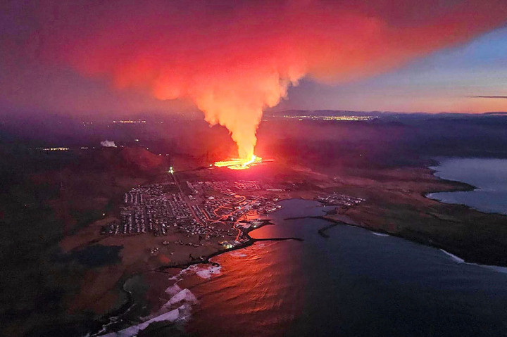 Asap mengepul dan lava yang mengalir selama letusan gunung berapi di pinggiran kota Grindavik, Islandia, Minggu, 14 Januari 2024.
