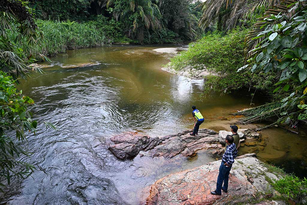 Petugas imigrasi memeriksa sungai dekat pusat penahanan imigrasi di Bidor di negara bagian Perak utara Malaysia pada 2 Februari 2024, setelah lebih dari 100 pengungsi Rohingya melarikan diri dari fasilitas tersebut.