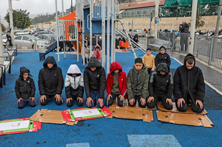 Muslim Palestina melaksanakan salat Jumat dengan sajadah memakai kardus di area bermain di jalan yang diblokir oleh pasukan keamanan Israel di lingkungan Ras al-Amud di Yerusalem timur, Jumat, 2 Februari 2024.