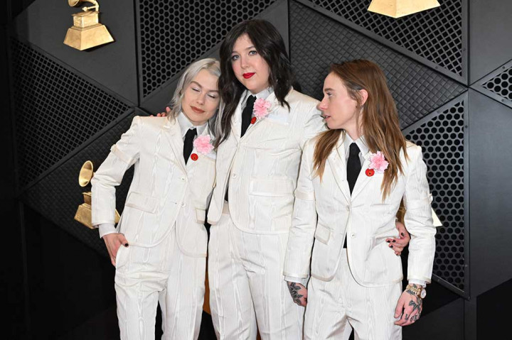 Ketiga anggota boygenius -- Phoebe Bridgers, Julien Baker dan Lucy Dacus -- naik ke atas panggung selama pra-upacara untuk menerima tiga Grammy mereka dalam setelan putih Thom Browne.