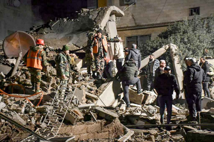 Petugas pertolongan pertama dan pasukan keamanan berada di lokasi yang baru saja dilanda pemboman Israel di kota Homs, Suriah, Rabu, 7 Februari 2024. 