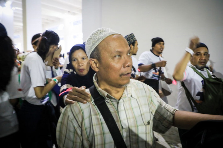 Berbagai atribut yang melekat di badan, serta umbul-umbul dan spanduk dibawa oleh massa yang mulai memadati tribun stadion.