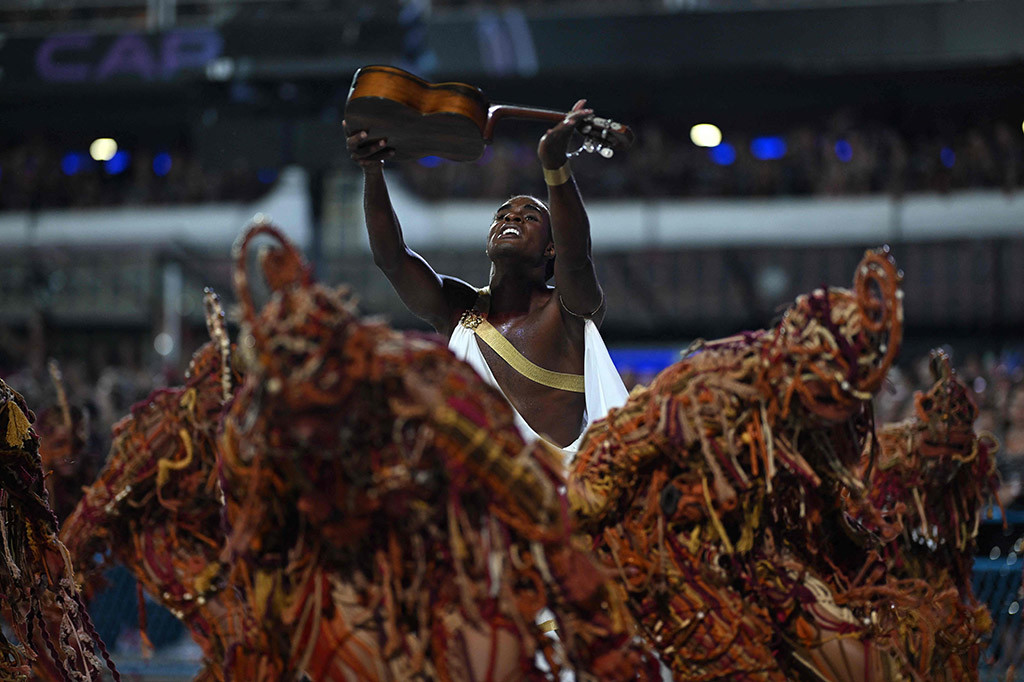 Berkilau dengan payet dan keringat serta bergoyang mengikuti irama samba yang gerah, ribuan pemain menari di jalan raya Rio de Janeiro pada hari Minggu, 11 Februari 2024 dalam parade karnaval terkenal di kota pantai Brasil itu.