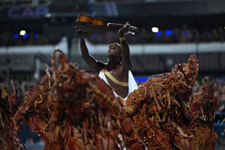 Berkilau dengan payet dan keringat serta bergoyang mengikuti irama samba yang gerah, ribuan pemain menari di jalan raya Rio de Janeiro pada hari Minggu, 11 Februari 2024 dalam parade karnaval terkenal di kota pantai Brasil itu.