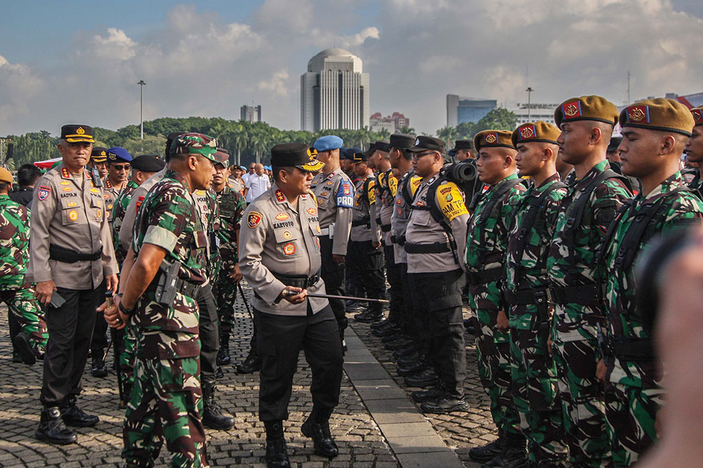 Kapolda Metro Jaya Irjen Karyoto dan Pangdam Jaya Mayjen Mohammad Hasan memeriksa pasukan saat apel pergeseran petugas pengamanan TPS di Lapangan Silang Monumen Nasional (Monas), Jakarta, Selasa, 13 Februari 2024. 