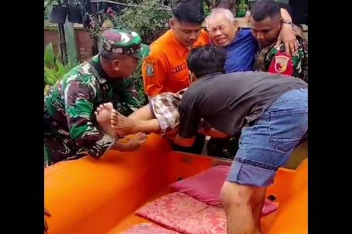 Ada juga seorang lansia laki-laki dievakuasi petugas BPBD Jatim bersama anggota TNI dibantu warga. Evakuasi menggunakan perahu karet, membawa lansia itu ke tempat aman yang kering.