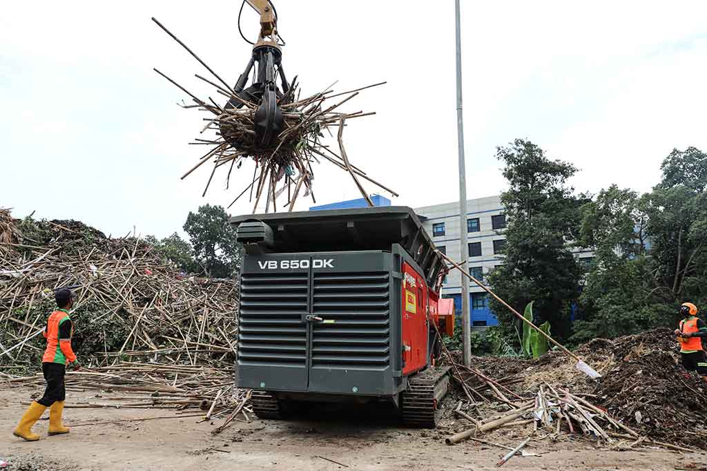 Petugas dari UPK Badan Air Dinas Lingkungan Hidup Provinsi DKI Jakarta menggunakan eskavator memasukkan sampah bambu bekas pemasangan alat peraga kampanye (APK) ke mesin pencacah di tempat penyaringan sampah TB Simatupang, Jakarta Selatan, Rabu, 21 Februari 2024.