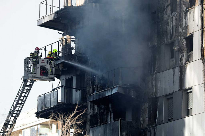 Asap masih mengepul dari dalam gedung dan dengan cepat tertiup angin kencang yang menyulut api serta mempersulit upaya pemadaman api. 