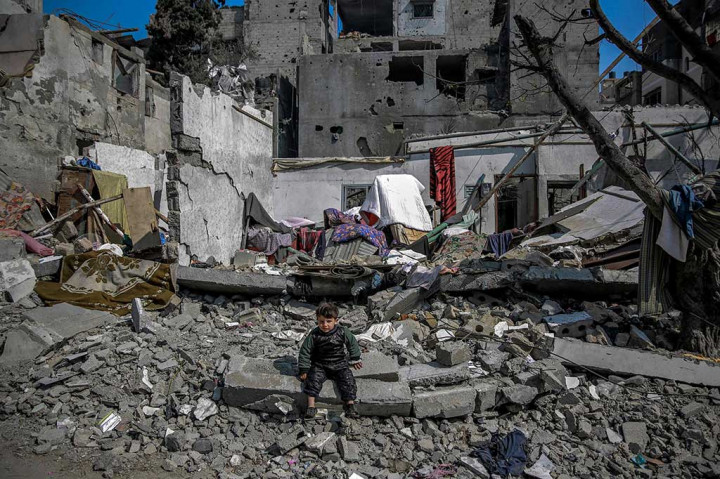 Seorang anak Palestina duduk di tengah puing-puing dekat bangunan yang hancur akibat serangan Israel di Beit Lahia di Jalur Gaza utara, Senin, 26 Februari 2024, di tengah berlanjutnya pertempuran antara Israel dan kelompok militan Palestina Hamas.