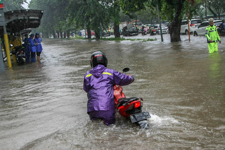 Seorang warga mendorong motornya yang mogok melintasi Jalan Suprapto, Cempaka Putih, Jakarta Pusat, yang tergenang banjir, Kamis, 29 Februari 2024.