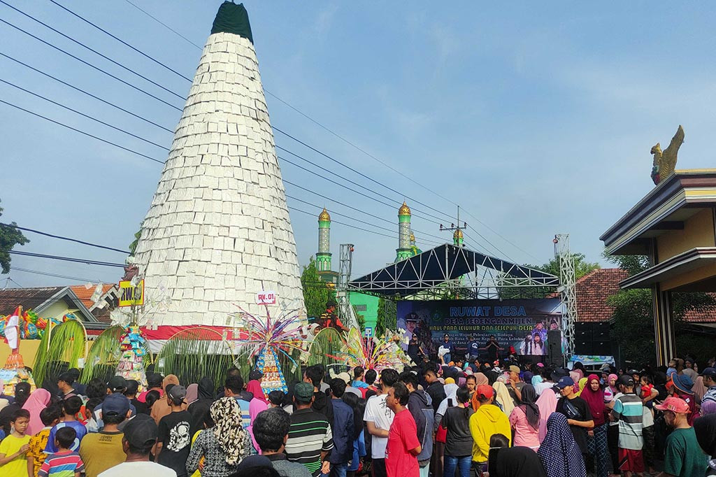 Warga Desa Sedenganmijen Kecamatan Krian Kabupaten Sidoarjo membuat tumpeng tempe raksasa setinggi 10 meter saat kegiatan ruwat desa, Minggu, 3 Maret 2024. Ruwat desa sebagai bentuk syukur kepada Tuhan Yang Maha Esa ini diwarnai rebutan oleh warga yang tidak mau bersabar.