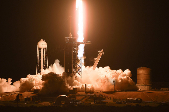 Roket SpaceX Falcon 9 lepas landas pada pukul 22:53 (0353 GMT Senin) dari Kennedy Space Center, menerangi langit malam dengan gumpalan api oranye yang panjang dan terang.