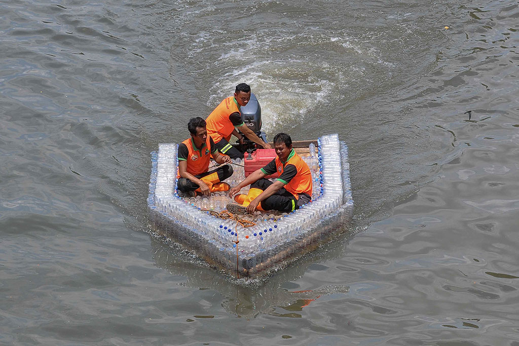 Petugas Unit Penanganan Sampah (UPS) Badan Air Kecamatan Duren Sawit, Jakarta Timur, menyulap botol plastik air mineral bekas menjadi perahu motor.