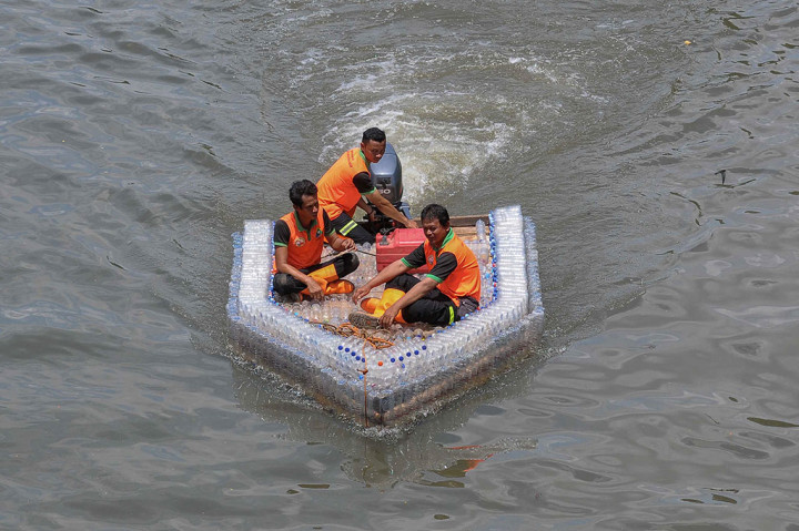 Petugas Unit Penanganan Sampah (UPS) Badan Air Kecamatan Duren Sawit, Jakarta Timur, menyulap botol plastik air mineral bekas menjadi perahu motor.